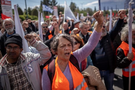 Protesters raise their fists as they march during a May Day (Labour Day) rally, marking International Workers' Day, outside the Greek Parliament in Athens.