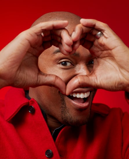 Close-up of Paul C Brunson holding his hands and fingers in a heart shape in front of his face