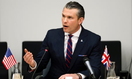Pete Hegseth gesturing as he speaks at a conference table