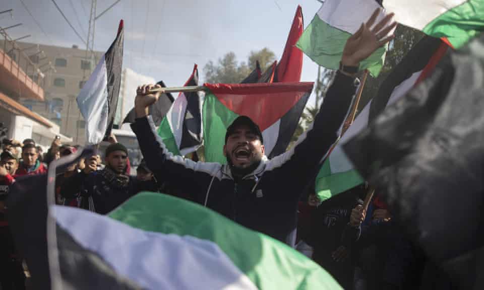 Palestinian protesters in Gaza City wave national flags and chant during a protest against the Donald Trump’s Middle East peace plan.
