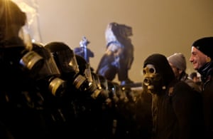 A demonstrator wearing a gas mask confronts policeman in a protest against new labour laws outside the Hungarian parliament in Budapest.