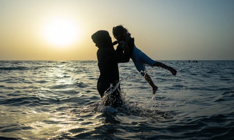 A Yemeni mother of four plays with one of her children in the Red Sea, near Hodeidah.