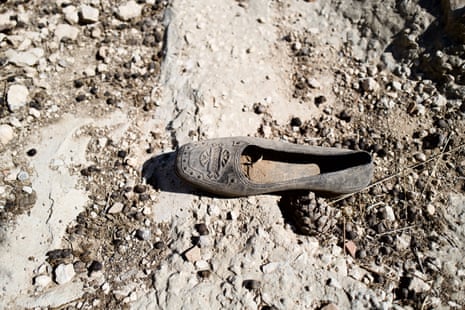 A dusty woman’s shoe lies forgotten on the ground