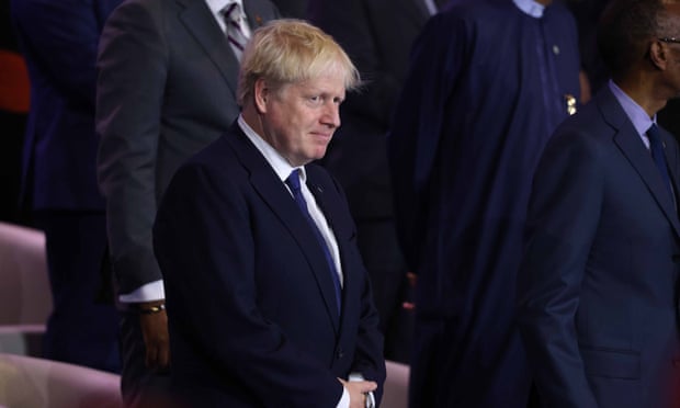 Boris Johnson in a suit with his hands folded