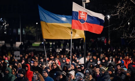People hold Slovakian and Ukrainian flags at a protest in Bratislava against Robert Fico’s pro-Russian government.
