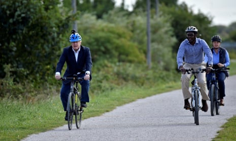 Boris Johnson (left) and and Darren Henry, the Conservative MP for Broxtowe (centre), riding bikes at the Canal Side Heritage Centre in Beeston earlier today.