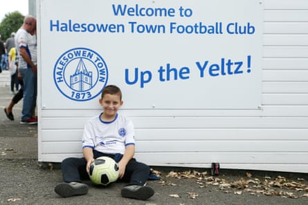 A young Halesowen fan in front of a sign saying Up the Yeltz