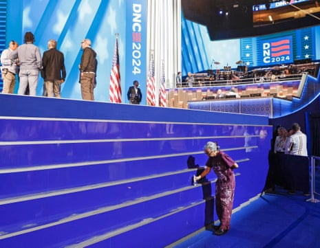 A painter applies a coat of paint to the stage in the United Center which will be the location of the evening activities at the 2024 Democratic National Convention in Chicago.