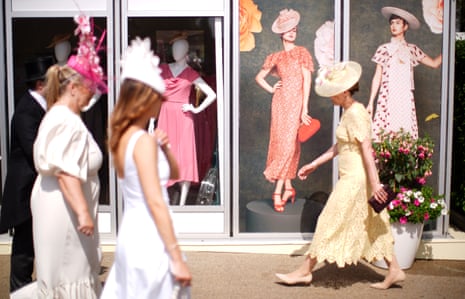 Racegoers walk past a fashion shop during day five of Royal Ascot.