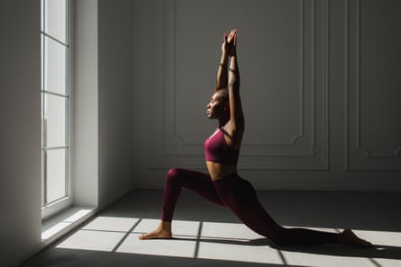 a woman doing yoga near a sunny window
