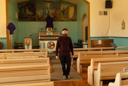 man stands among pews