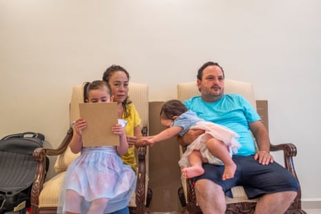 A man and a woman sit with children on their laps/