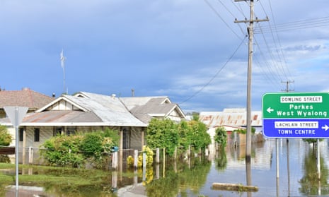 Houses and street signs reflected in the flood waters surrounding them