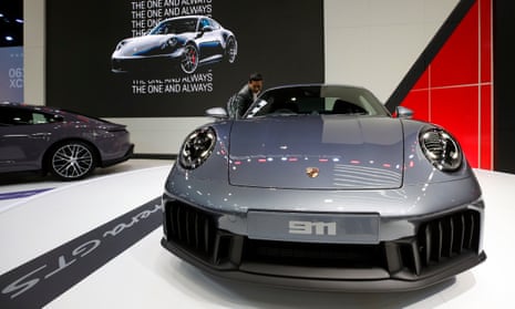 Visitor checks a grey car photographed from the front