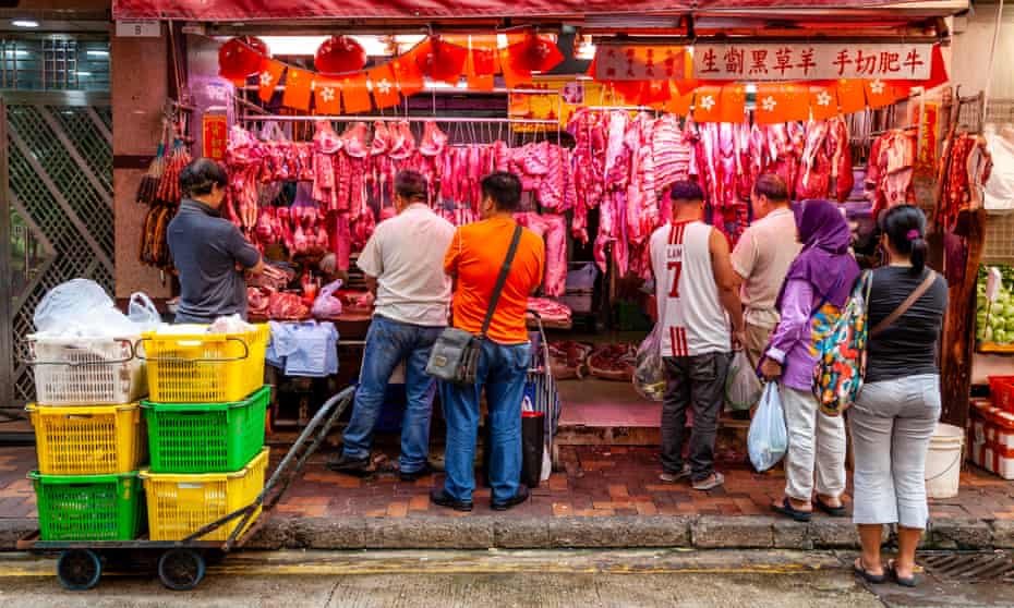 People buy meat at a butchers’ shop at the Bowrington Road food market in Hong Kong.