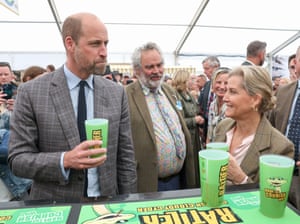 Prince William and Sophie try local cider in green cups in a pavilion
