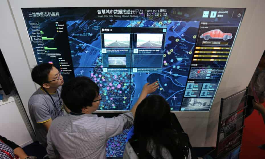 Visitors look at a screen displaying a smart city system at the 18th China Beijing International High-Tech Expo in Beijing, China, 13 May 2015.