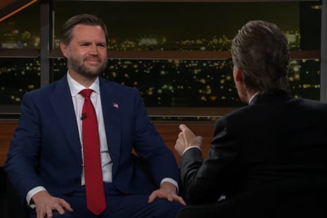 Two men in suits speak to each other.