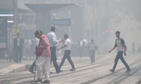 pedestrians walk in smoke haze in the city