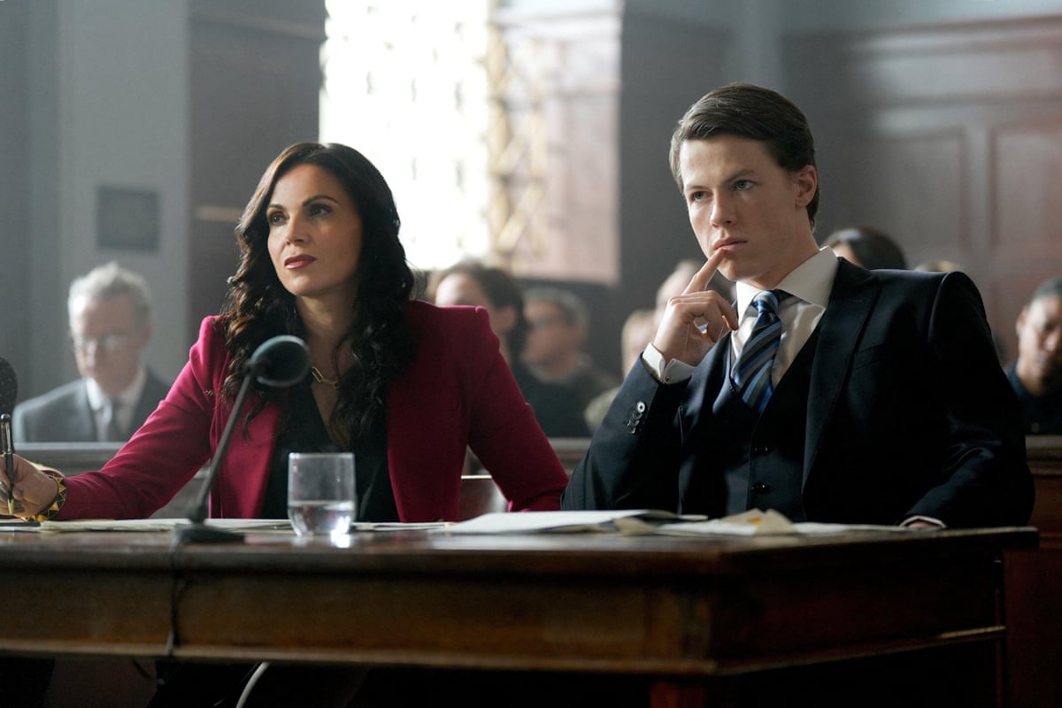 Two women in a courtroom setting wearing smart suits