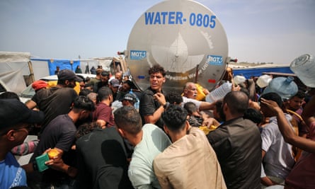 People tussling to fill their water containers in Deir al-Balah in central Gaza in April.