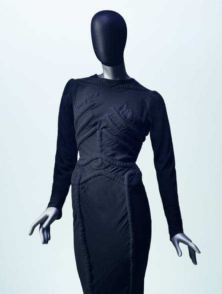 A mannequin wearing a dark black dress decorated with bones
