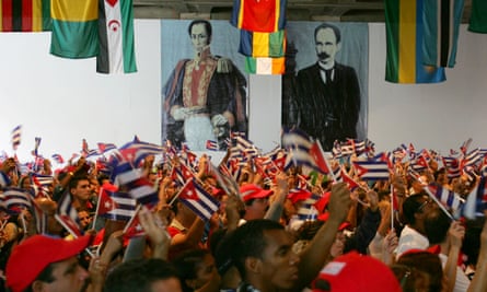 Members of the Cuban delegation wave flags beneath portraits of the South American libertor Simón Bolívar and the Cuban national hero José Martí at the World Social Forum in Caracas, Venezuela, in 2006.