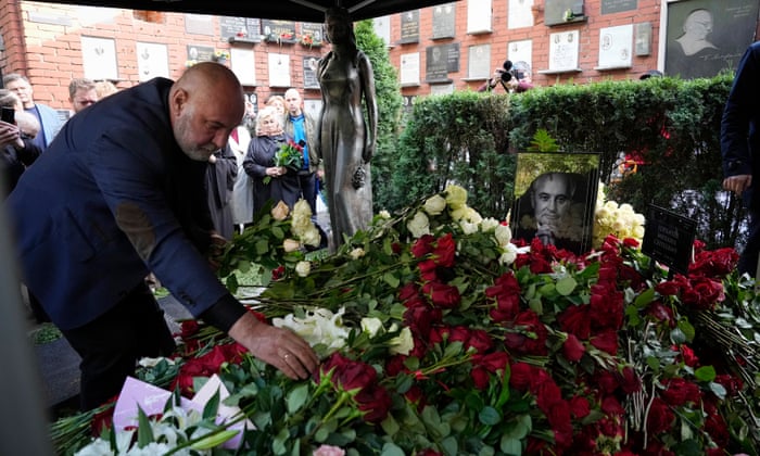 A man lays flowers on the grave of the former leader.