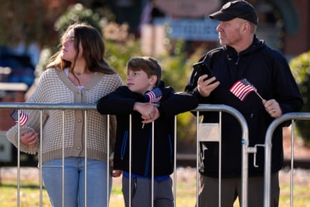 Family leans on police barricade with US flag