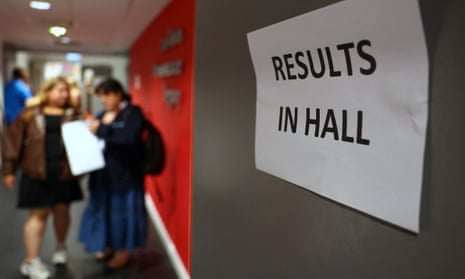 Sign reading "Results in hall" as people open A level results in the background