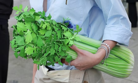 A model holding a clutch that resembles a bunch of celery