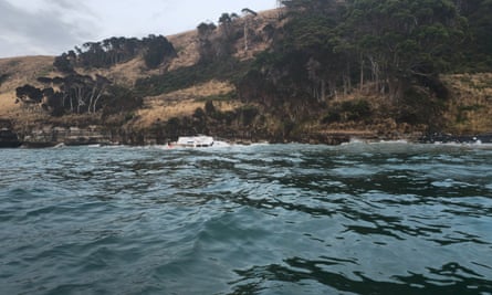 A boat crashed up against a rocky shoreline