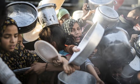 Palestinians in Rafah, Gaza, queue to receive food distributed by aid organisations on 15 March, 2024.