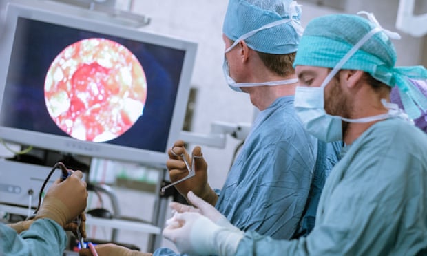 Neurosurgeons in scrubs during an operation.