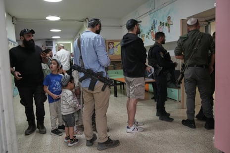 Israeli settlers queue to vote at a school serving as a polling station in Kiryat Arba, in the occupied West Bank