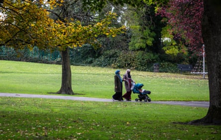Two Muslim women with a buggy walking in a park Two Muslim women with a buggy walking in a park
