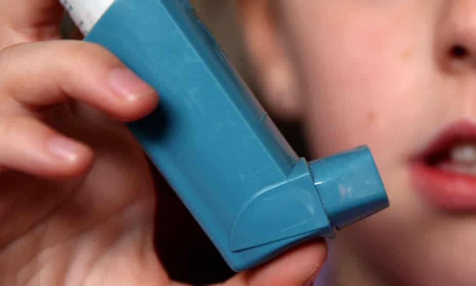 A person using an inhaler for the treatment of asthma