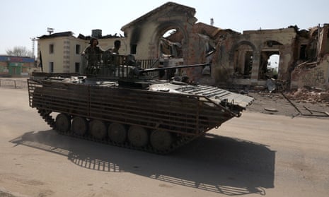 Ukrainian servicement drive an infantry fighting vehicle past the rubble of a destroyed rail statio in the town of Kostyantynivka in the Donetsk oblast.