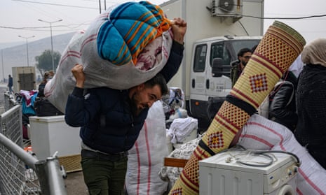 A Syrian man living in Turkey carries his belongings at the Cilvegozu border crossing gate in Reyhanli on on the way back to Syria.