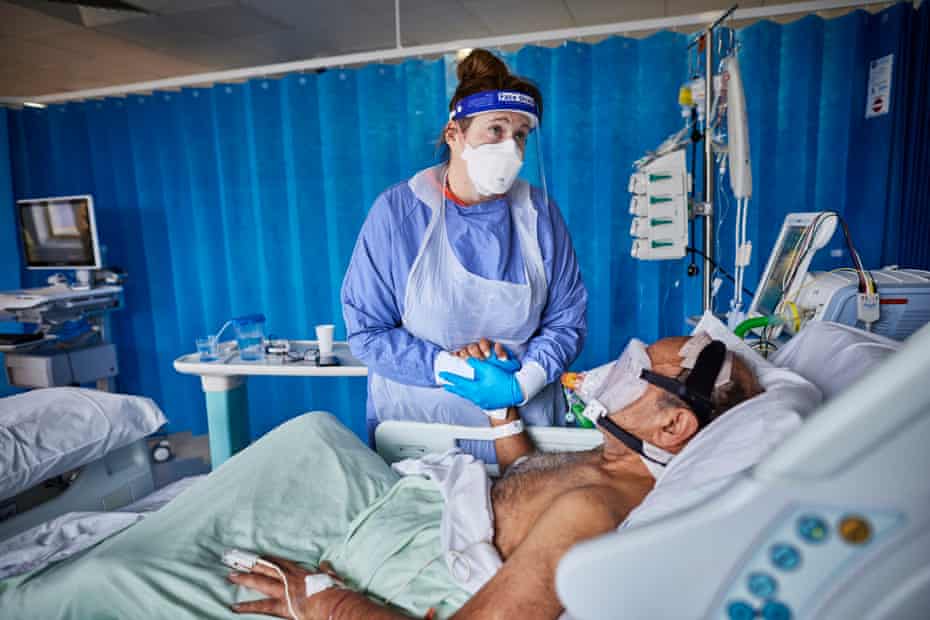 Nurse Kim James comforts a gravely ill Covid-19 patient on the ICU ward at Milton Keynes hospital during the UK’s second Covid wave, 7 January