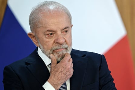 a man in a suit holds his hand to his chin