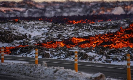 Lava on the edge of snow-covered ground directly next to a road
