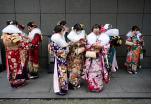 Kimono-clad young Japanese women wearing protective face masks gather near the venue holding the Coming of Age Day ceremony amid the coronavirus disease (COVID-19) pandemic, in Yokohama