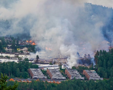 Smoke and flames rise from a huge fire that has spread from terraced houses by the Krokstadelva in Drammen, Norway.