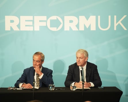 Nigel Farage sits alongside Danny Kruger under a Reform UK banner
