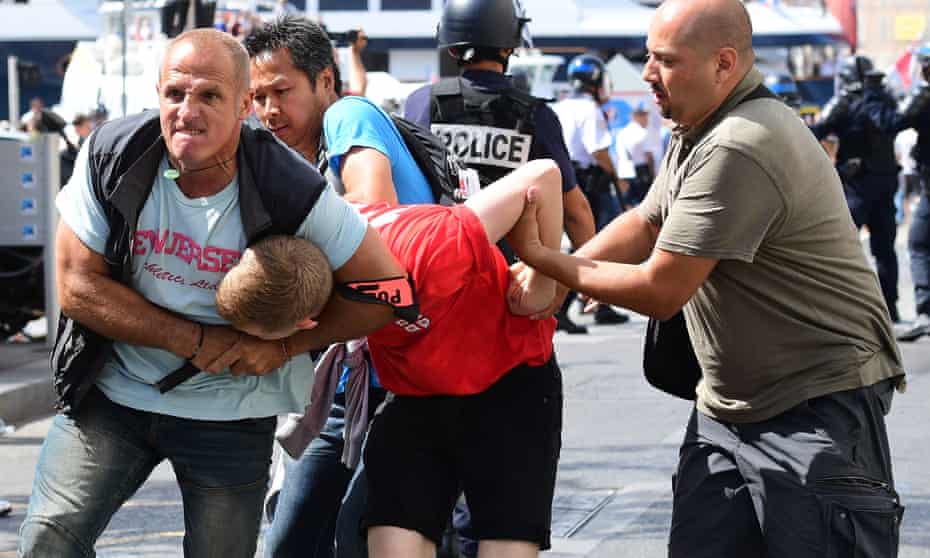 An England fan is detained by police following clashes between England fans and police in Marseille, France