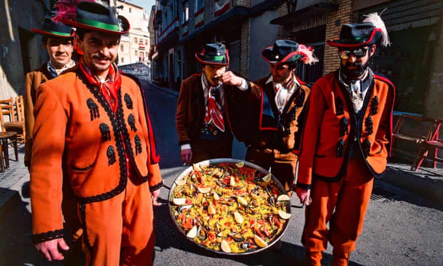 Men in traditional costumes carry a paella pan during the Moors and Christians festival in Bocairente, Valencia, Spain.