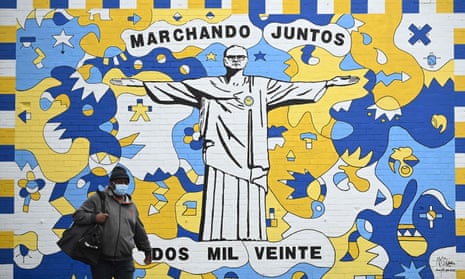 A pedestrian walks past a mural depicting Leeds United’s Marcelo Bielsa as Christ the Redeemer.