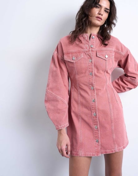 A model wears the dusty pink short denim long-sleeved dress from Topshop