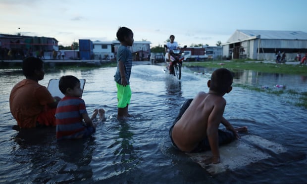 Boys play in flood waters on Tuval, an island that is extremely vulnerable to climate change
